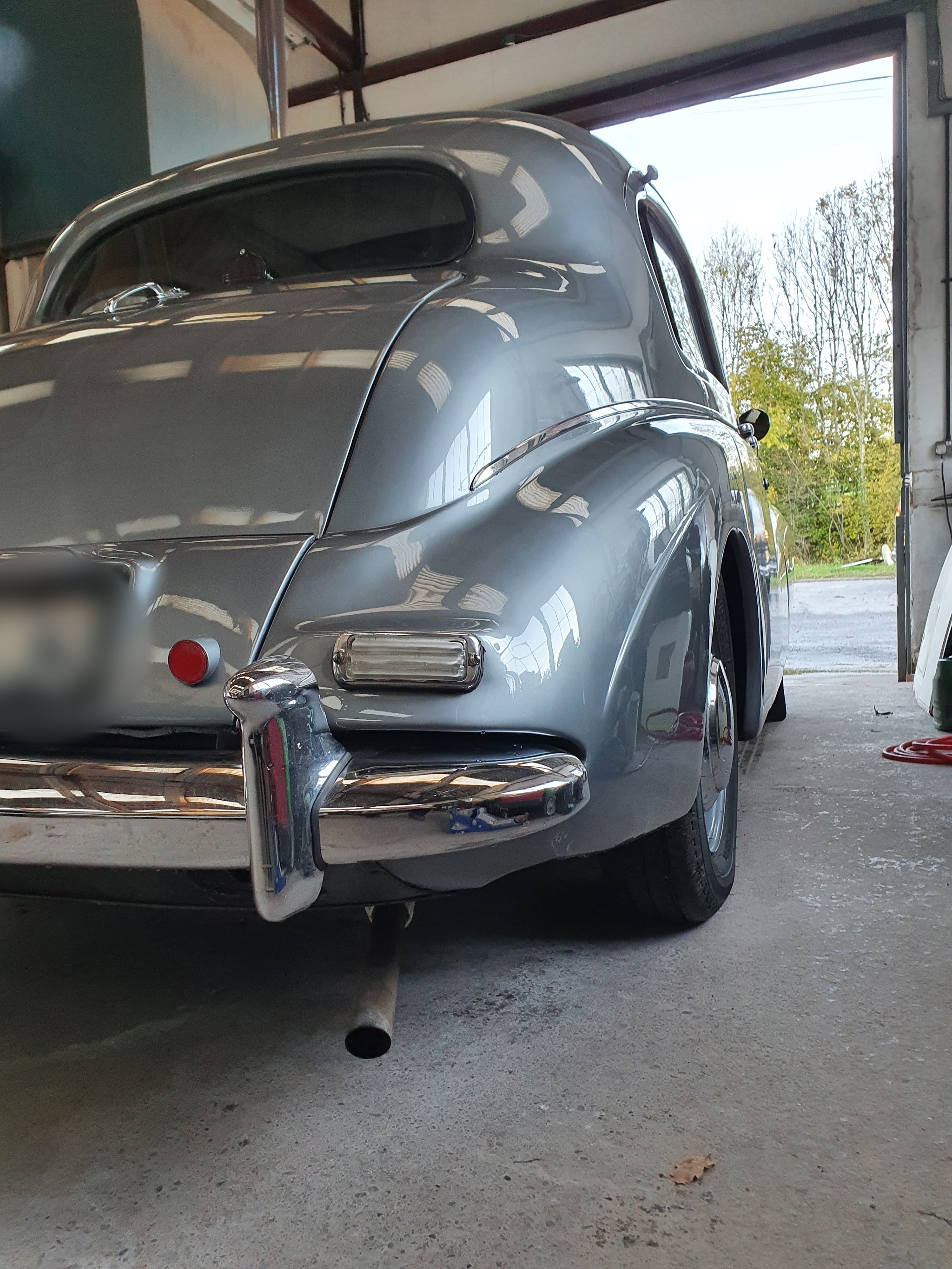 After: the same rear wing reshaped and repainted with the lamp back in, in the workshop doorway